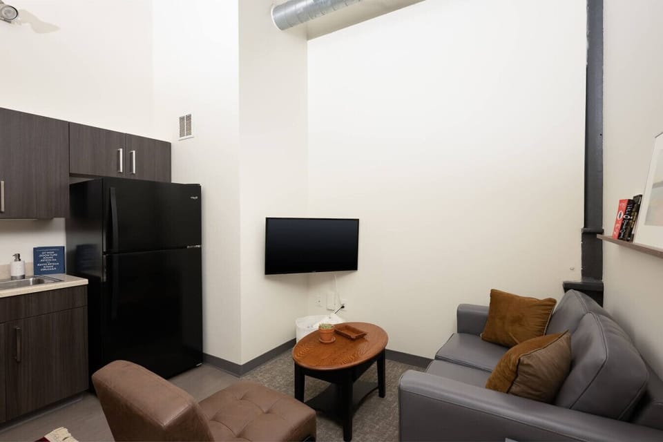 Living room with soaring ceilings, seating areas, and dining/work table