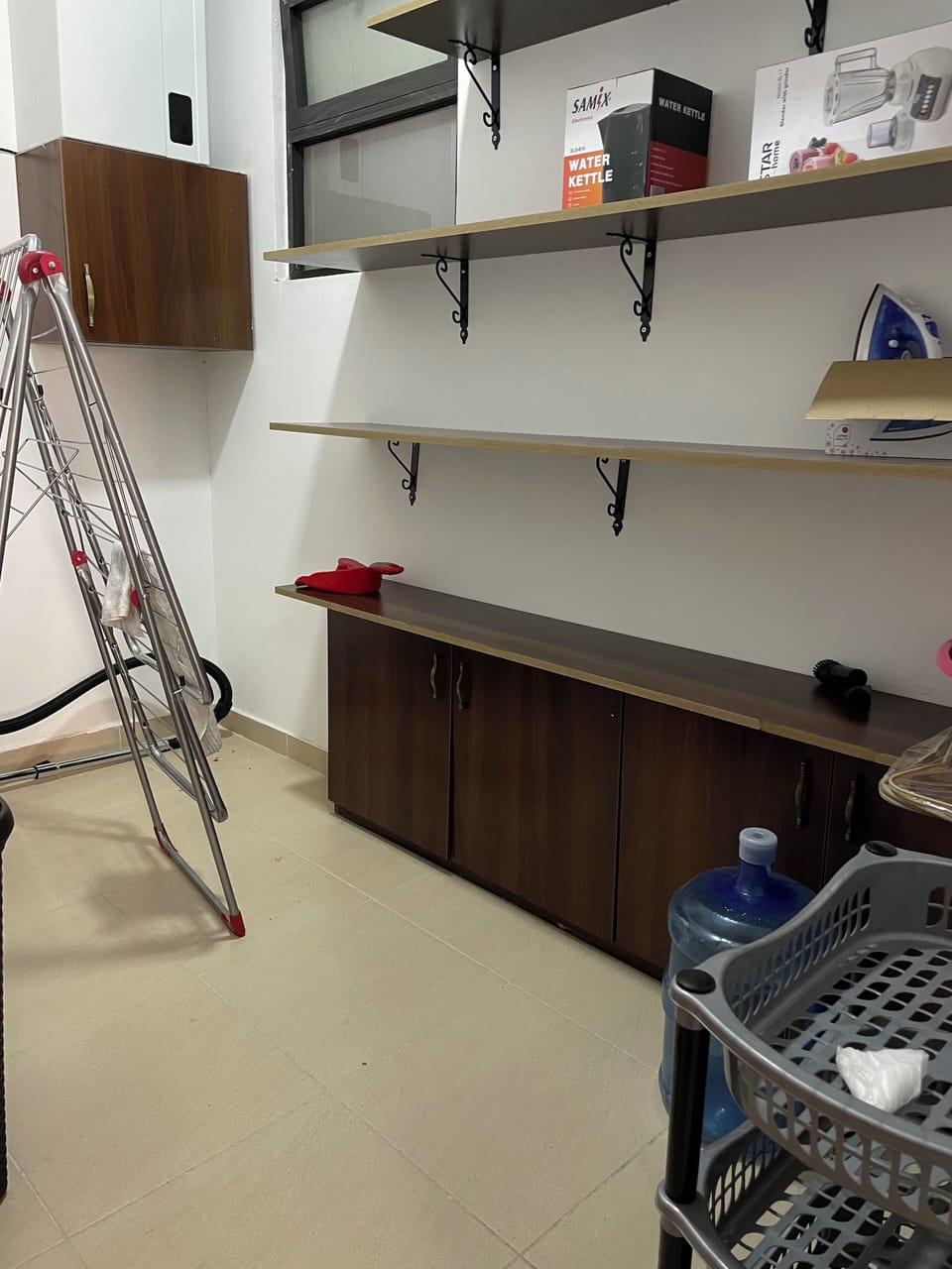 utility room with clothes hanger, iron, hair dryer, cleaning supplies