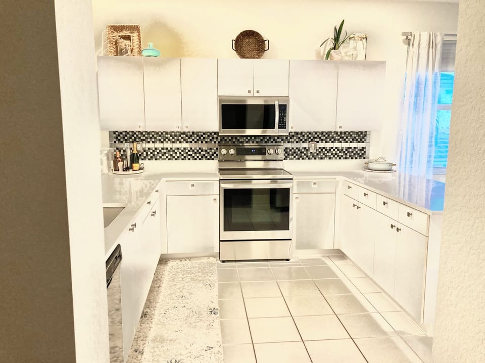 Huge open kitchen w/quartz, stainless, breakfast bar, bright sunny windows