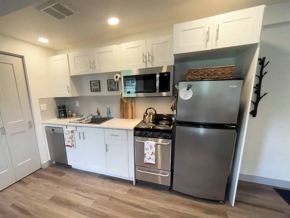 The kitchen main appliances are a four-burner range with oven, microwave, dishwasher, and fridge. 