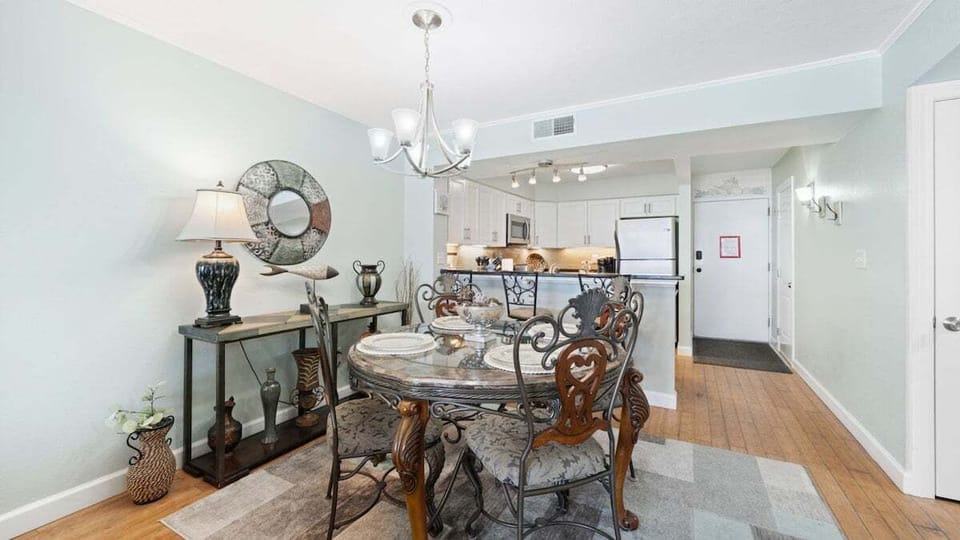 Elegant dining area with seating for six, a cozy breakfast bar, and coastal décor—perfect for meals or game night.