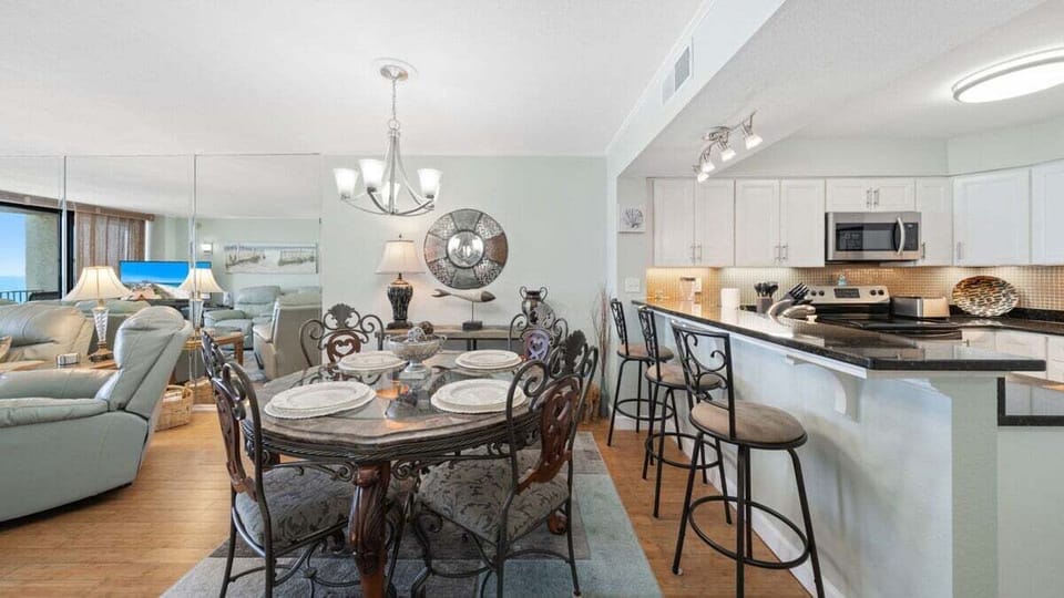 Gather for meals or game night in the inviting dining area, which features elegant seating for six and a spacious bar counter with additional stools.