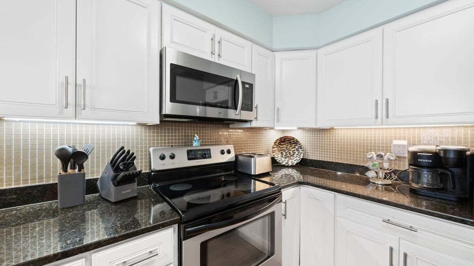 This fully equipped kitchen features sleek granite countertops, stainless steel appliances, and all the essentials you need.
