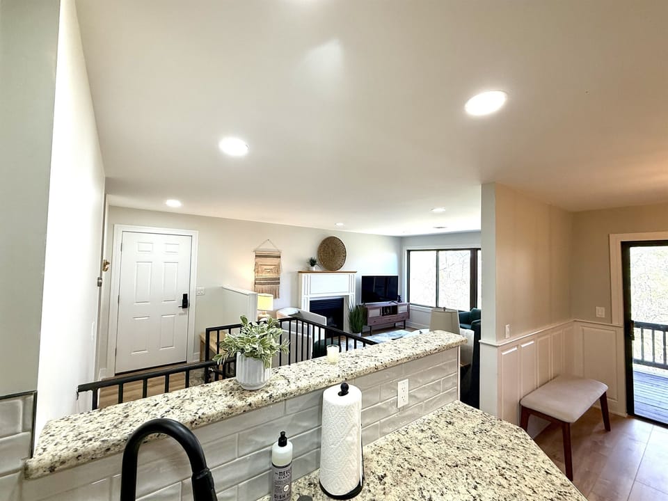 Fully stocked kitchen overlooks main floor living room, dining room, and front door. 