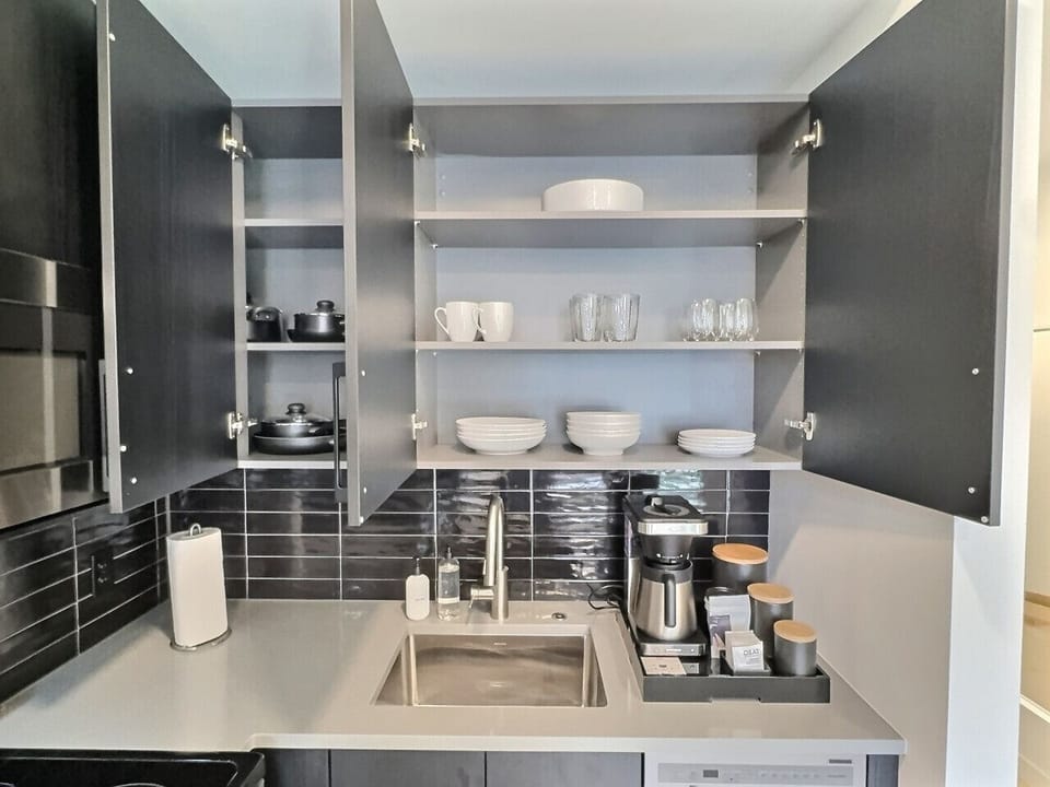 Modern kitchen with sleek stainless steel appliances and neatly arranged utensils, perfect for effortless cooking during your short-term rental stay.