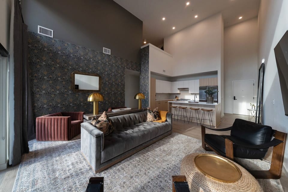Stunning open-concept living space, tall ceiling and stylish patterned accent wall, and comfortable seating area.