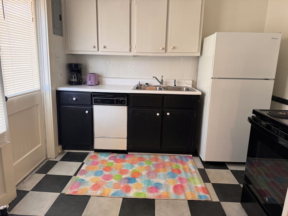 Full Kitchen with fridge, oven, stove, microwave, pots, pans, plates, cups