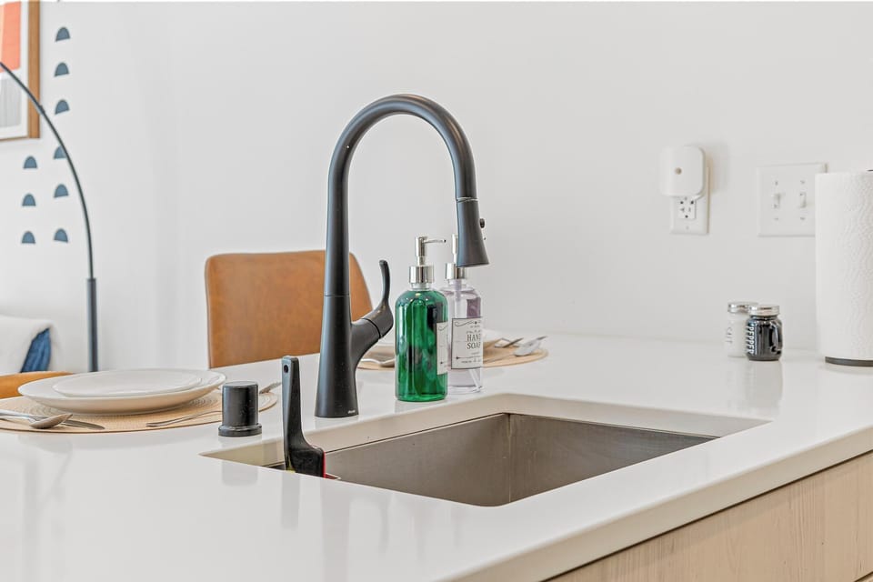 Modern kitchen island with stylish black faucet and bright white counters