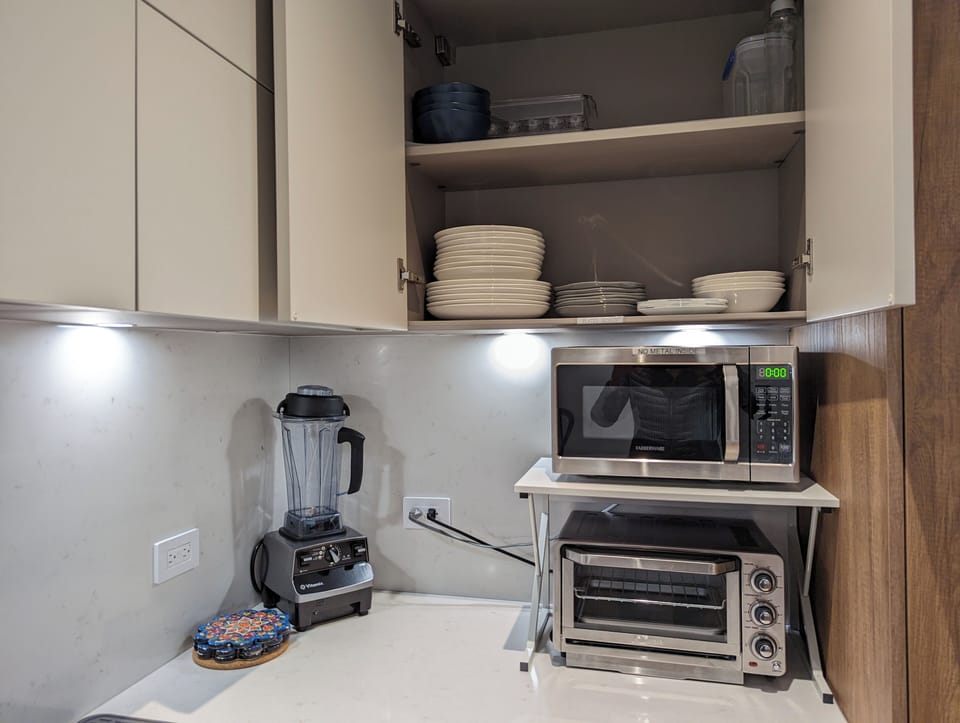 Appliances corner. Microwave with baking toaster oven. Plates and bowls.