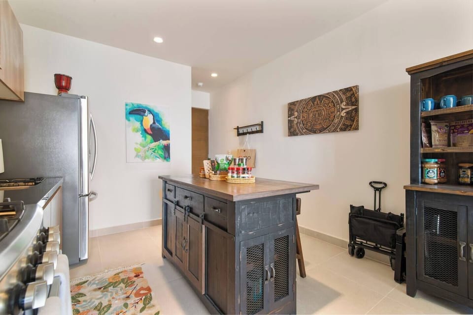 Well-equipped kitchen with full fridge, freezer, and a convenient kitchen island.