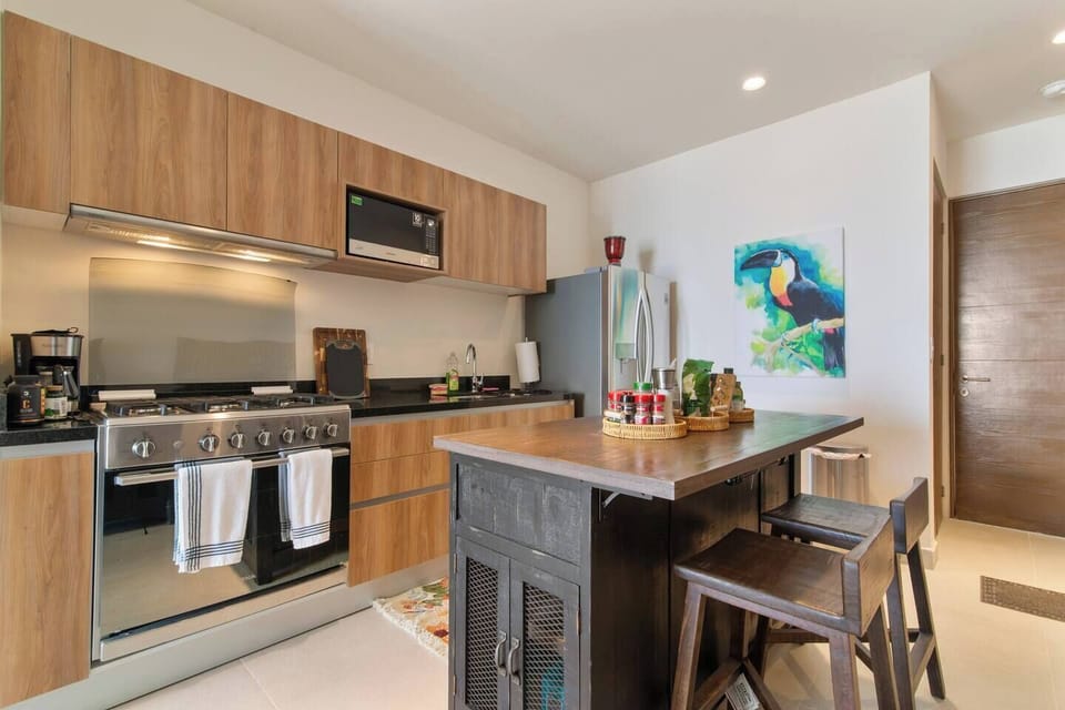 Well-equipped kitchen with microwave, blender, toaster, stove, and oven.