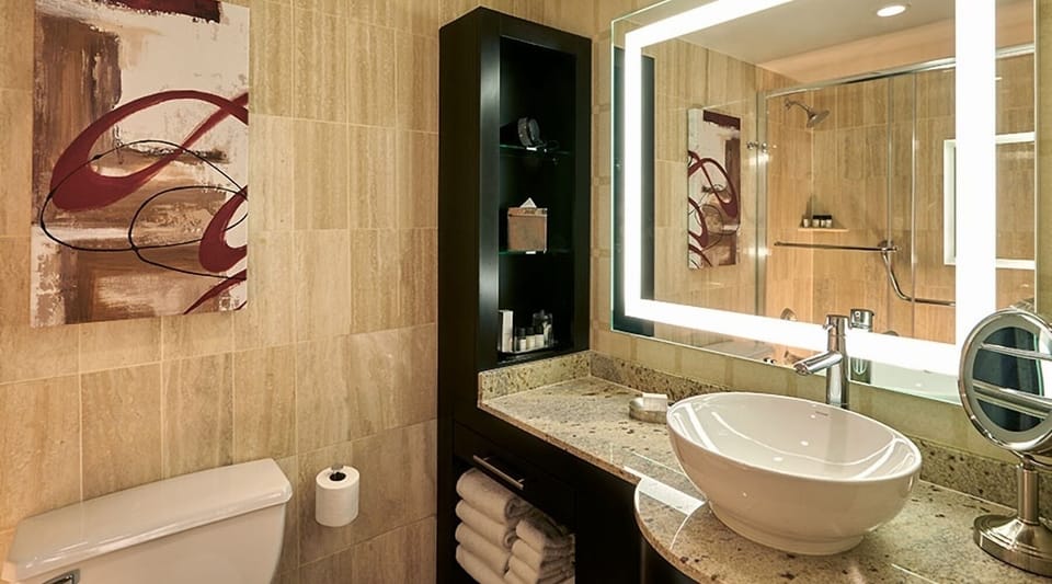 Refresh at a sleek vanity with glowing mirror lighting.