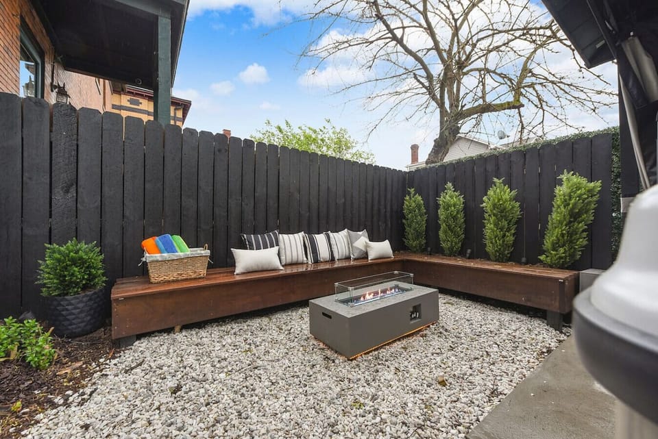 Relax on the cozy outdoor bench by the fire pit—perfect for an evening under the stars.