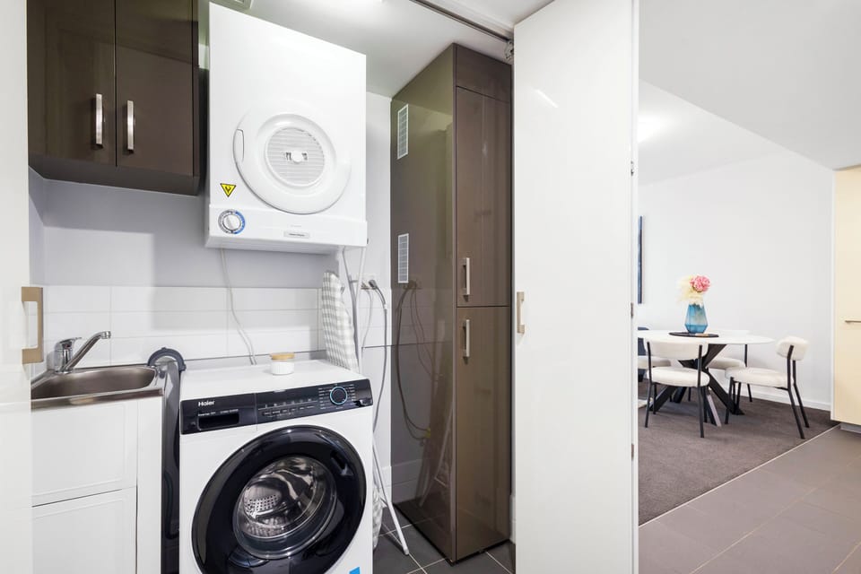 Discover the convenience of a well-organized laundry area, neatly integrated with storage and a practical sink. 