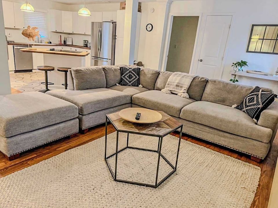 Spacious living area with a cozy sectional and open kitchen, perfect for family gatherings and relaxation.