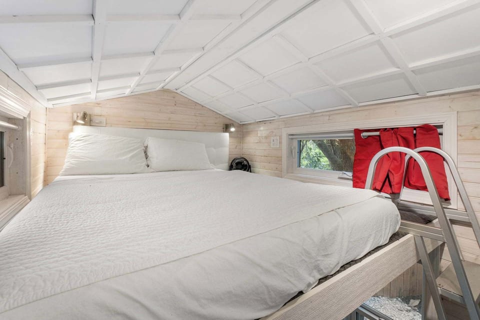 Cozy loft bedroom with serene views and inviting bedding, perfect for a peaceful retreat.