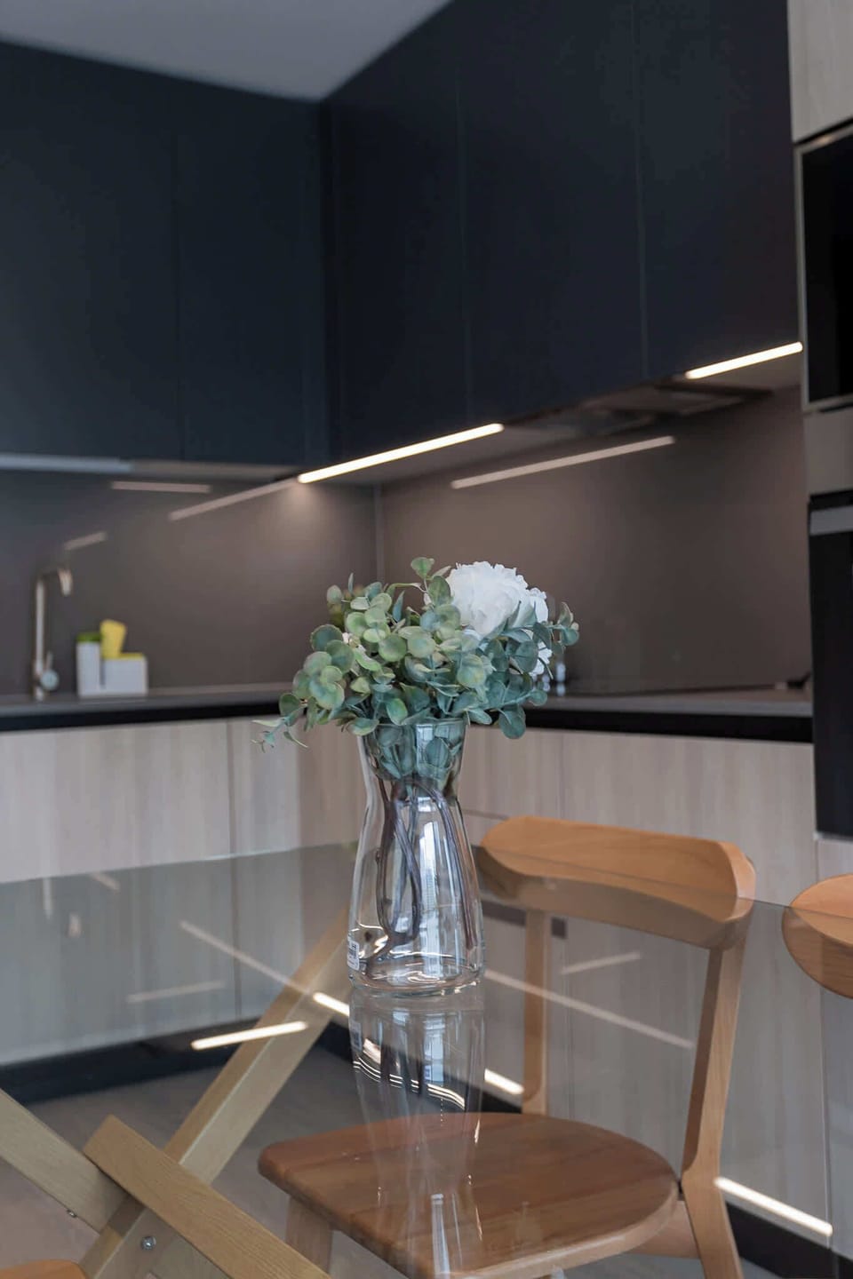 Experience modern elegance in this stylish kitchen, featuring sleek cabinetry and a cozy dining area perfect for meals and gatherings.