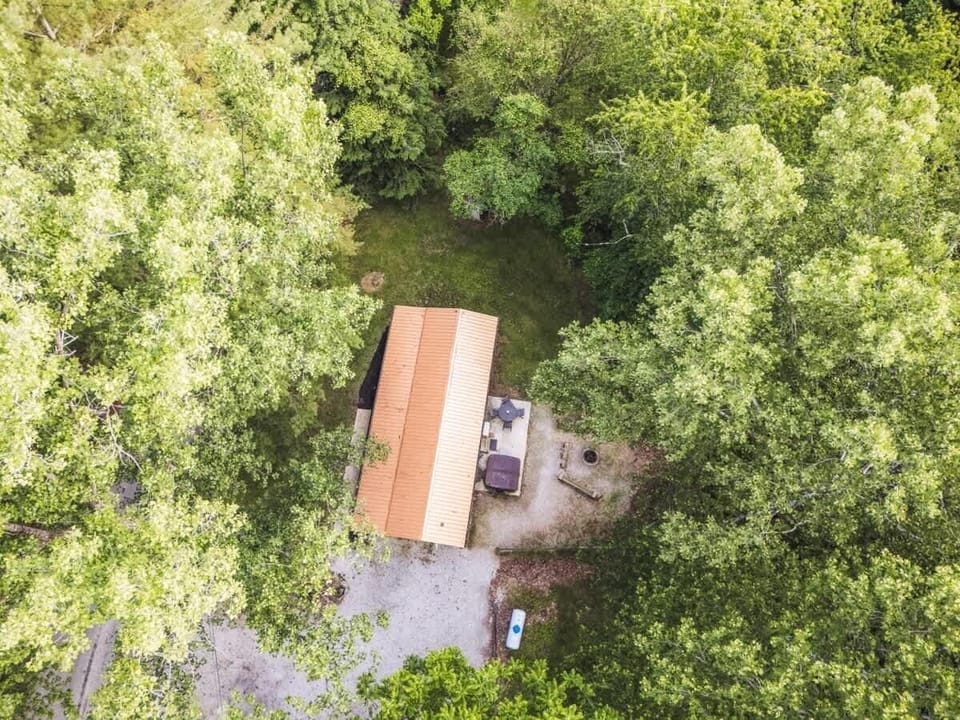 Aerial view of the cabin tucked beneath a lush canopy of trees for a peaceful retreat 🌲