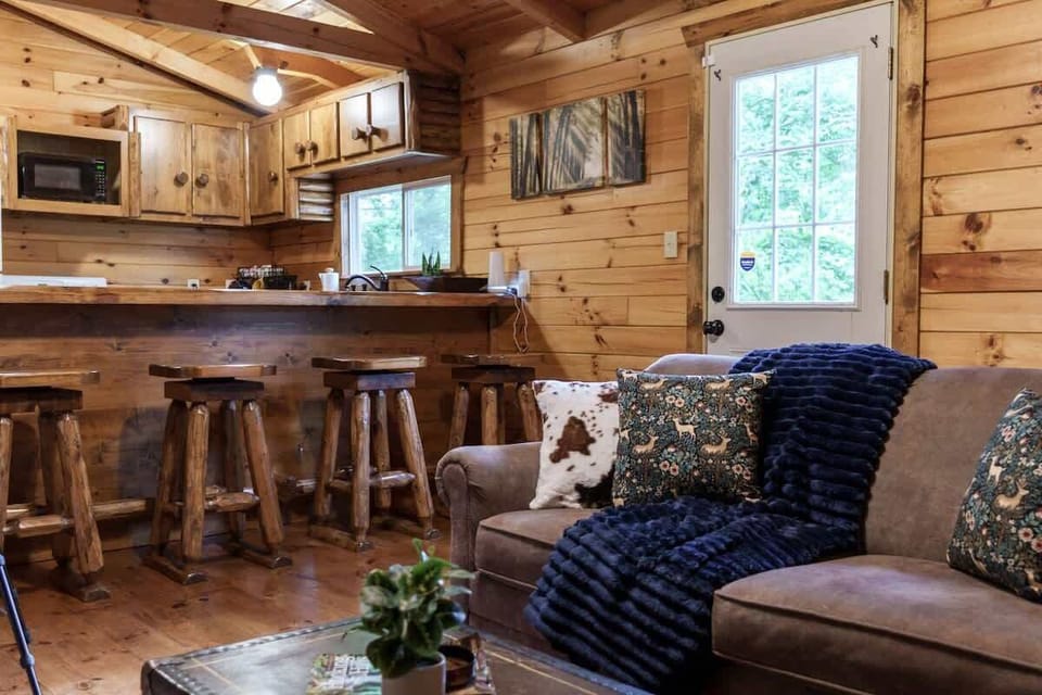 Cozy cabin kitchen & living area w/ bar seating, wood cabinets & open space to gather