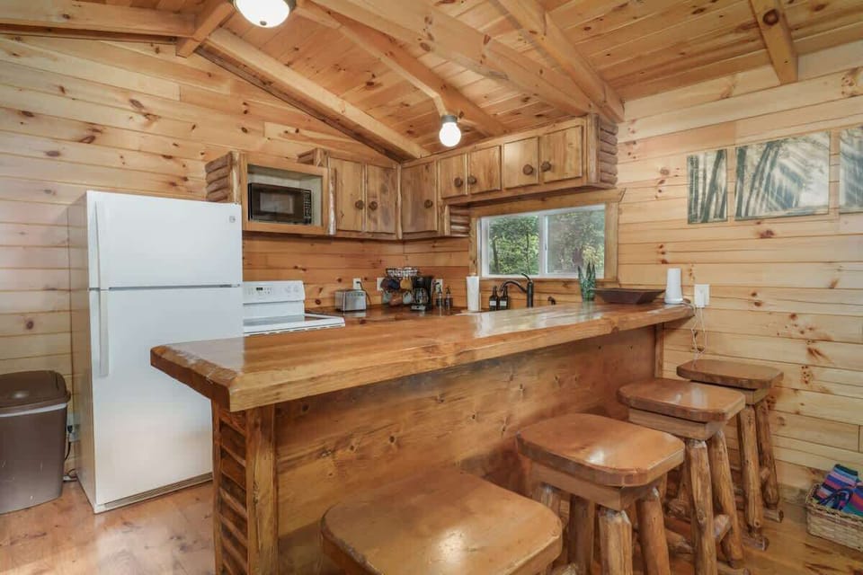 Rustic kitchen bar w/ wooden stools, perfect for morning coffee or casual meals after a day outdoors