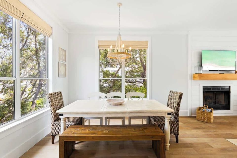 Dining room table includes seating for 6 and features large windows bringing in natural light.
