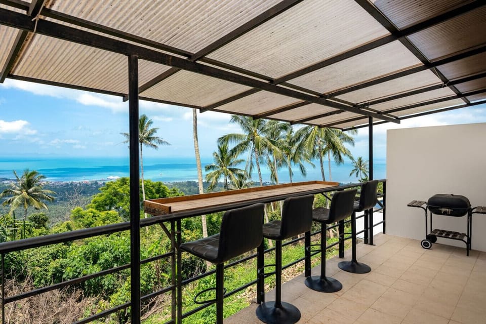 Contemporary entrance with grand staircase and natural light at Moonview Paradise Village Koh Samui