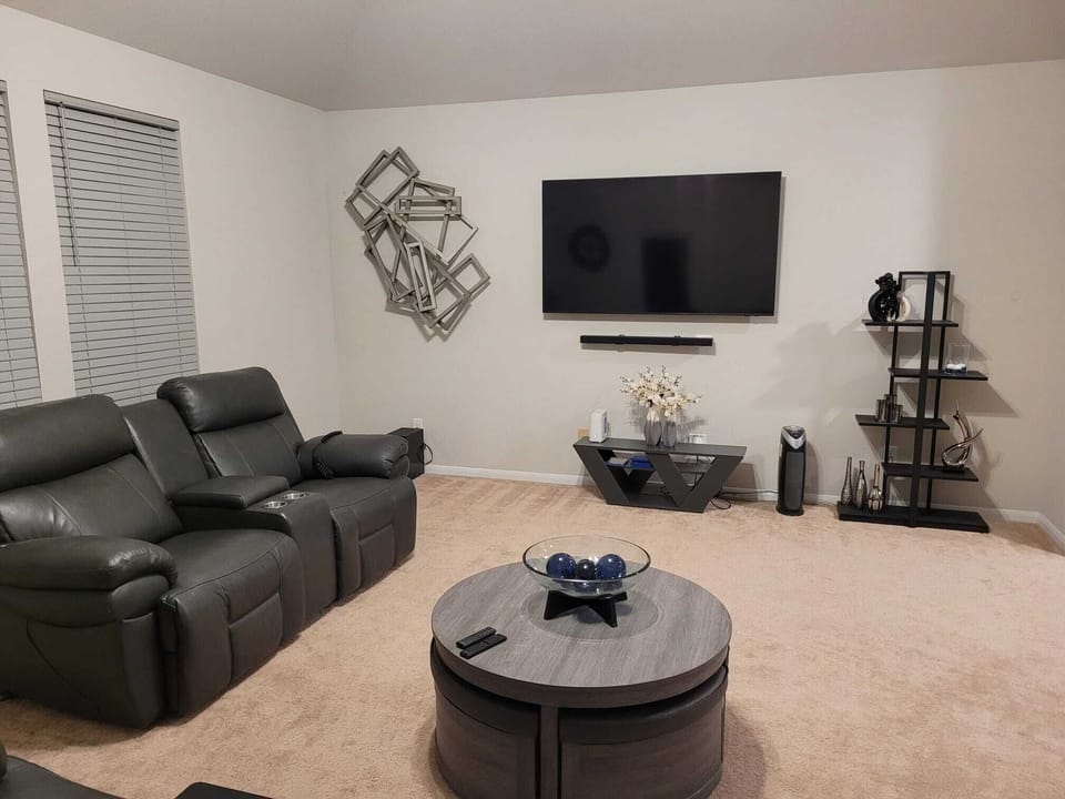 Family room with Samsung Smart TV, soundbar, and zero gravity recliners