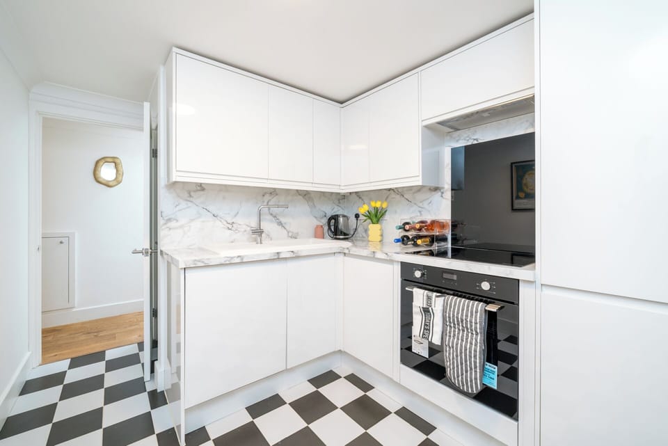 This sleek, fully equipped kitchen features elegant marble countertops, high-gloss cabinets, and modern appliances to make your stay seamless.