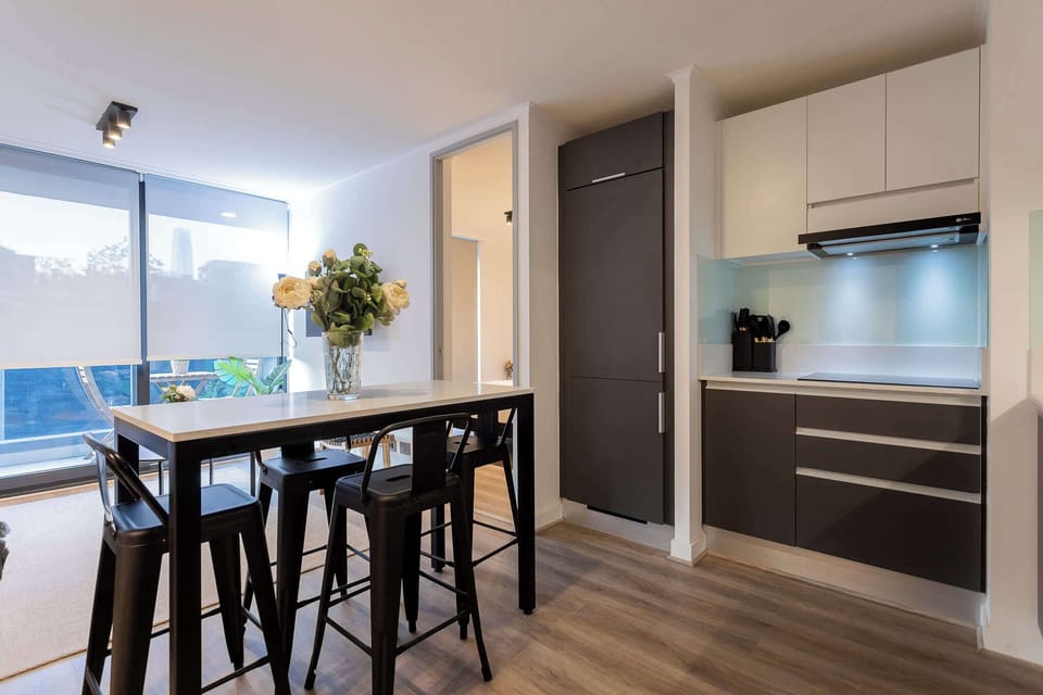 Experience modern living in this stylish kitchen, featuring sleek cabinetry, bar seating, and abundant natural light for a welcoming atmosphere.