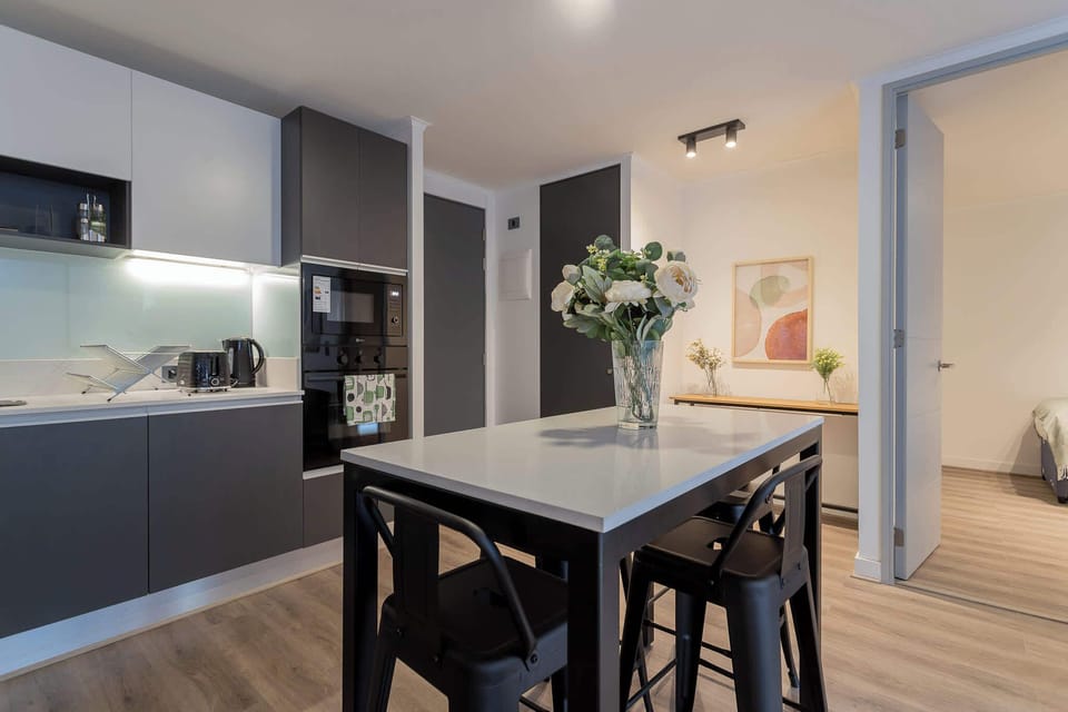 Experience modern living in this stylish kitchen, featuring sleek appliances and a cozy dining area perfect for gatherings.