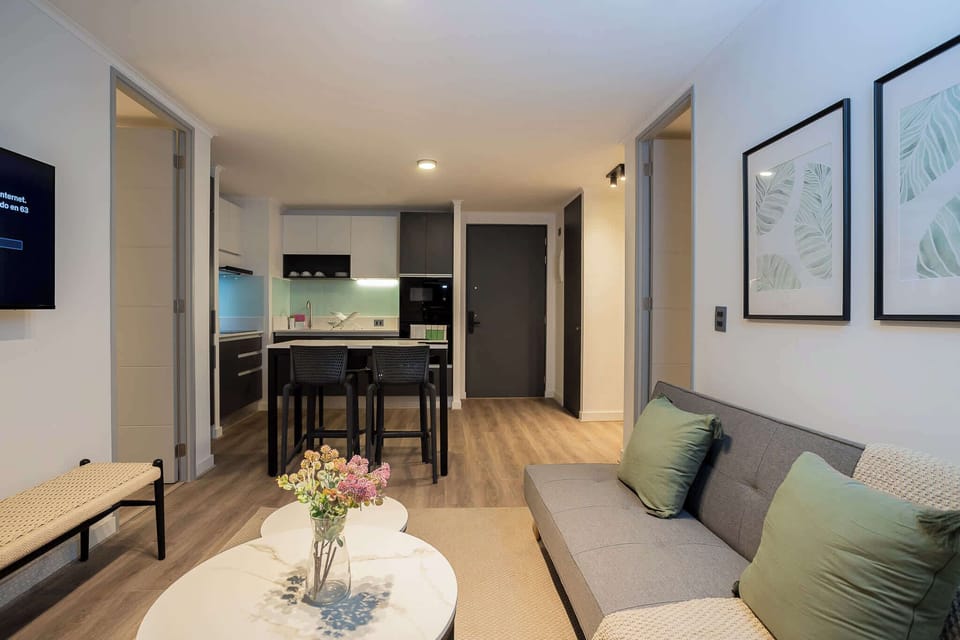 Chic living area with cozy seating and modern kitchen, perfect for relaxing or entertaining in style.