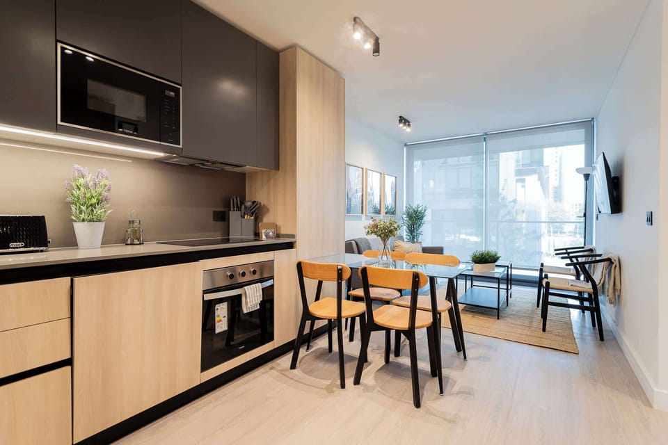 Experience modern living in this stylish kitchen, featuring sleek appliances and a bright dining area perfect for gatherings.