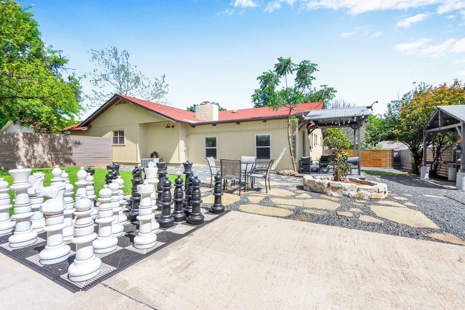 Welcome to Checkmate and Chill-Inn! Unwind with a giant game of chess and enjoy outdoor dining in a backyard retreat