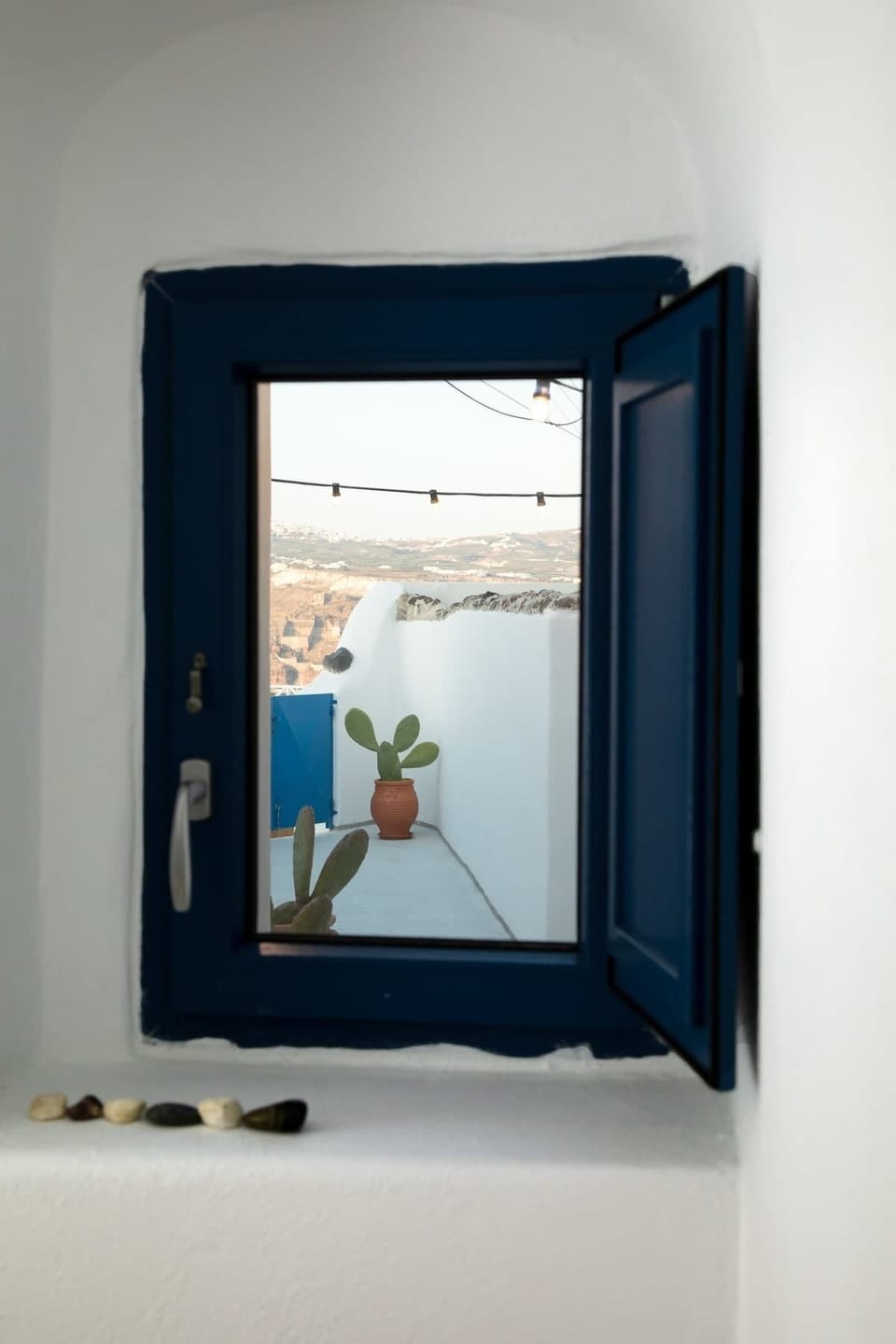 Window View Framing the Aegean Landscape
Look out to a beautiful island scene framed through a classic wooden window.