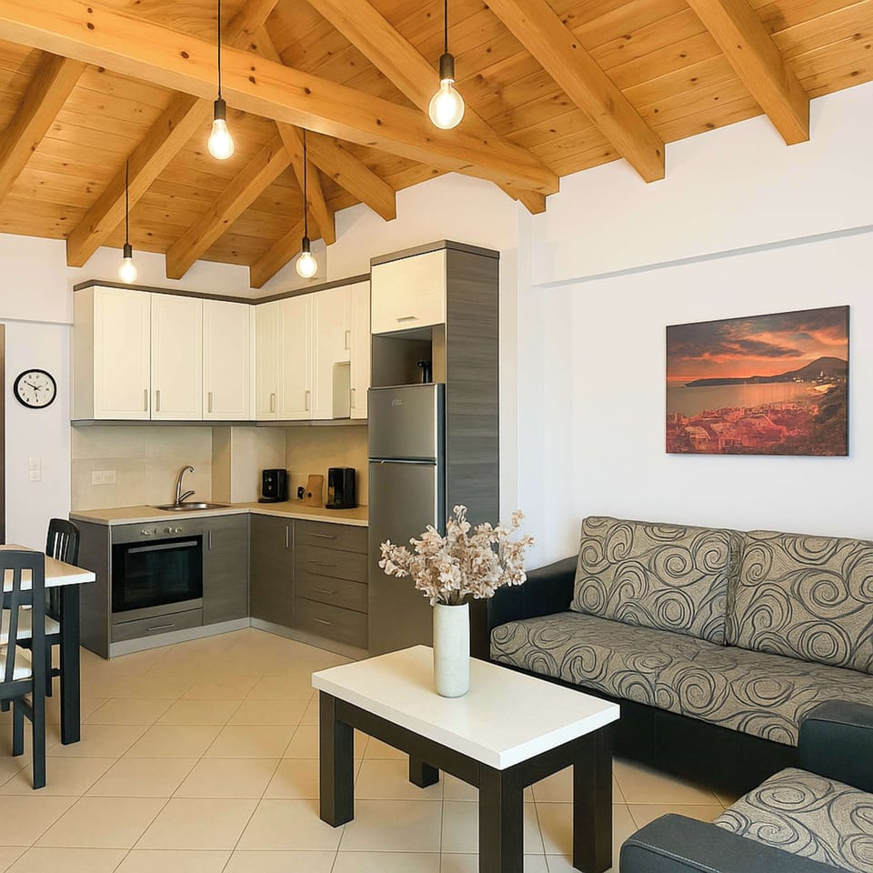 Airy, high-ceilinged living area featuring a fully equipped kitchen, comfy seating, and smart layout