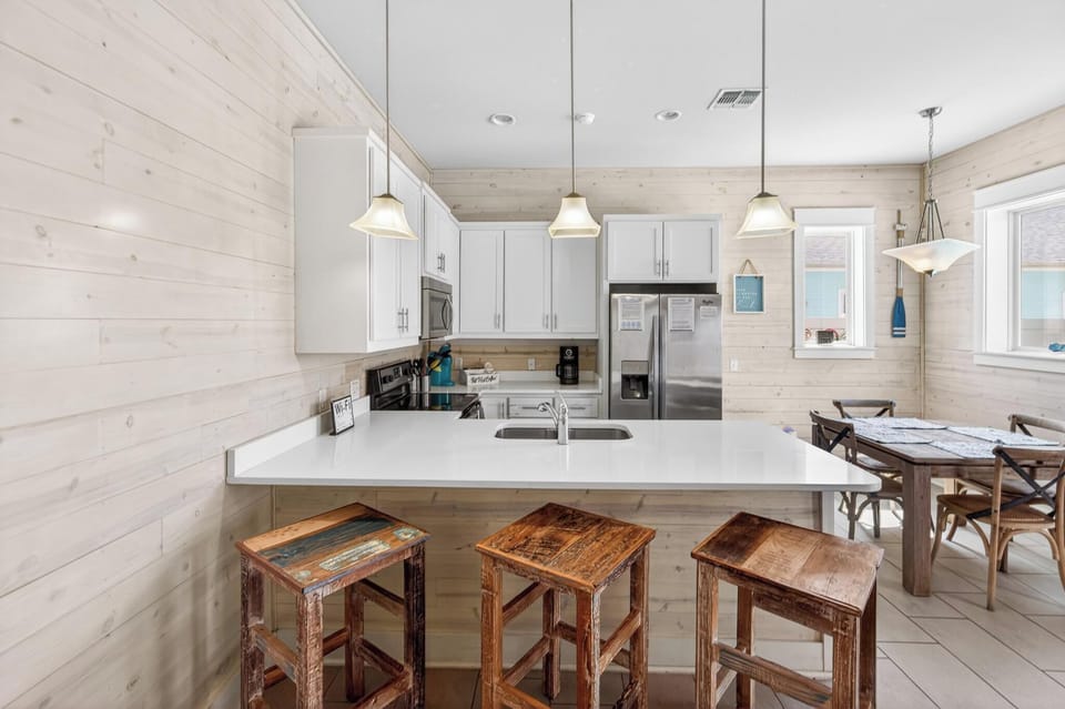 Bright and fully equipped kitchen with bar seating perfect for meals, coffee, and conversation!
