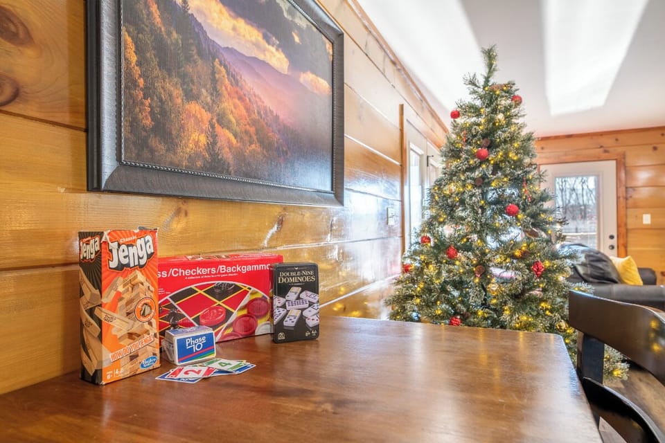 Cozy up for festive game nights with board games ready and a beautifully lit Christmas tree creating magical holiday ambiance.