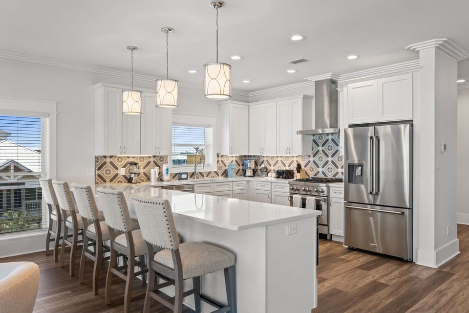 Cook your favorite meals in this bright, fully-equipped kitchen with modern appliances, a spacious island for prep work, and elegant pendant lighting that sets a welcoming mood for your getaway.