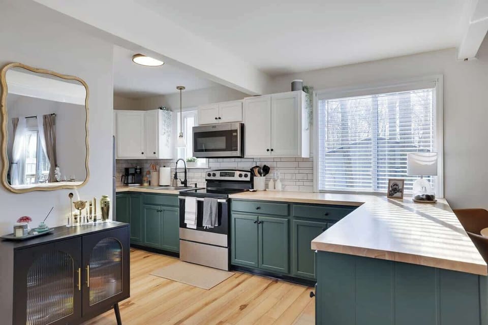 Kitchen: Bright and stylish space with green cabinets, modern appliances, and inviting natural light!