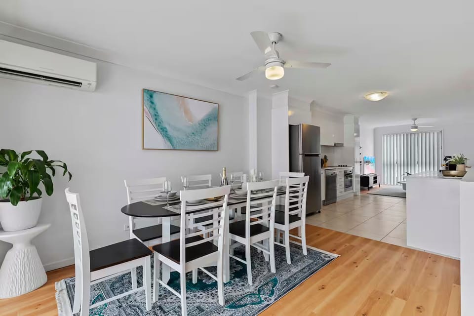 Dining area seats eight with air-conditioning and ceiling fan coverage.