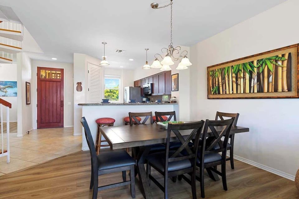 - Dining table with bamboo wall art
- Kitchen bar connects open layout
- Red front door adds warm welcome