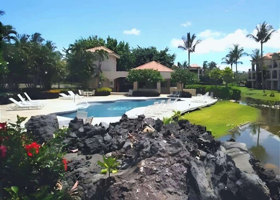Lounge poolside in a beautiful, tropical setting surrounded by palm trees and lava rock gardens.