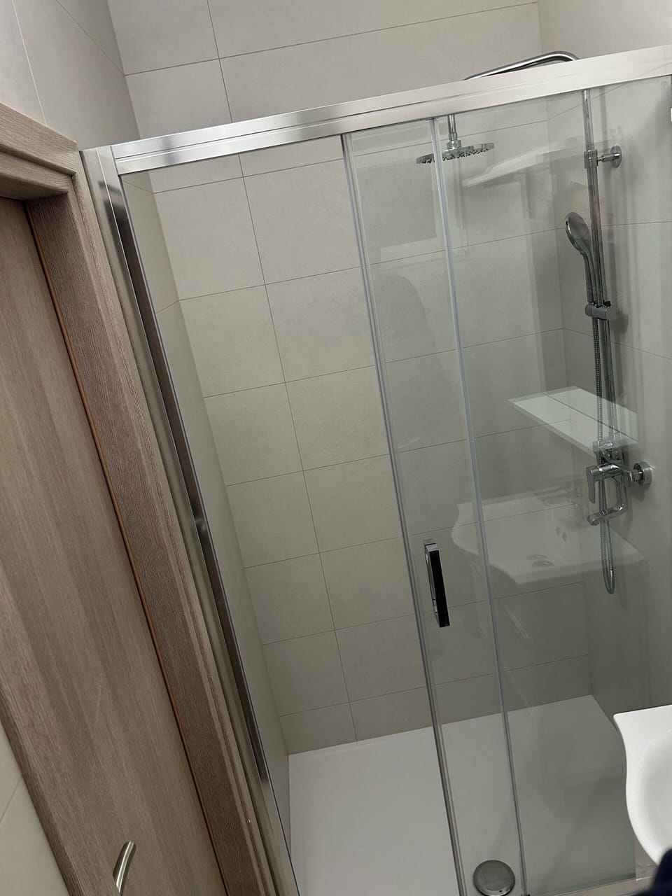 Spacious walk-in shower with glass enclosure.