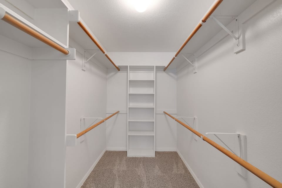  A walk-in closet with ample shelving, hanging space, and effortless elegance.