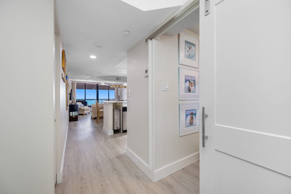 View from the hallway into the open-concept living and kitchen area with ocean views.