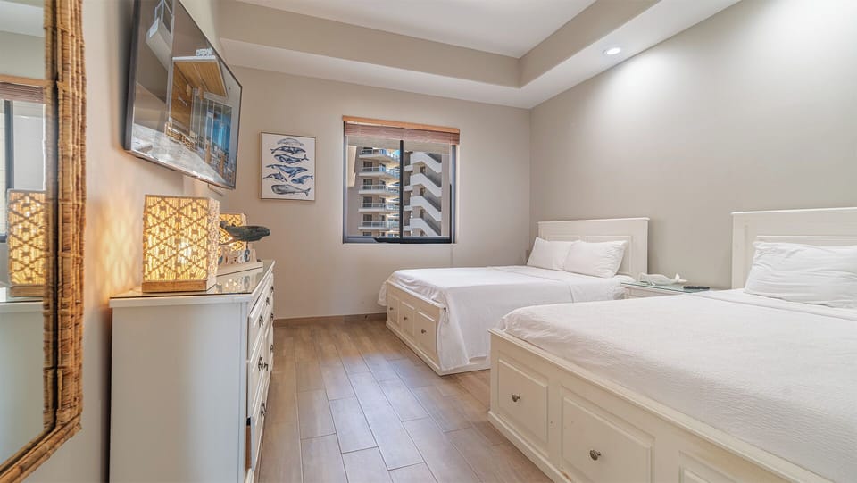 bedroom three offers two queen beds, dresser, TV, and closet