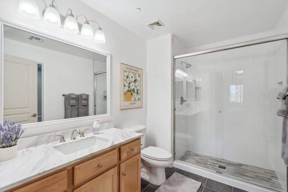 The Primary Bathroom includes a spacious single vanity and a walk-in shower with a clean, modern design.