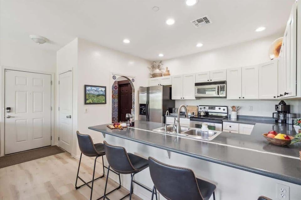 The Kitchen showcases a clean look, stainless steel appliances, and bar seating for four in a stylish, functional layout.