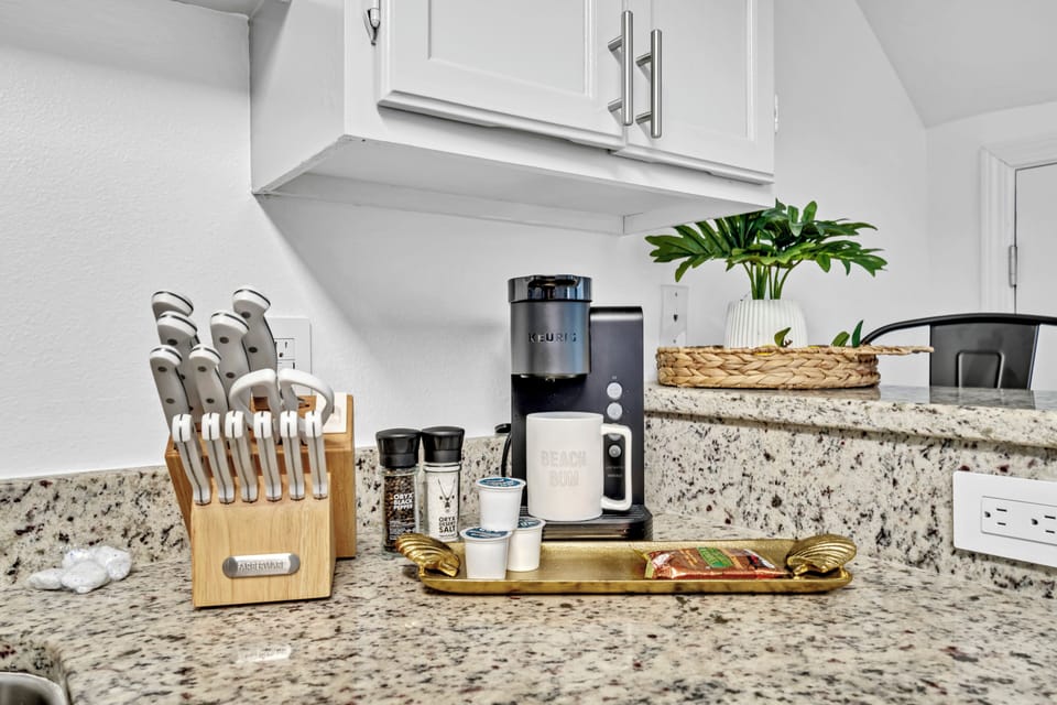 Your fully equipped kitchen features granite counters, quality appliances, and thoughtful touches like fresh plants to make cooking feel like home.