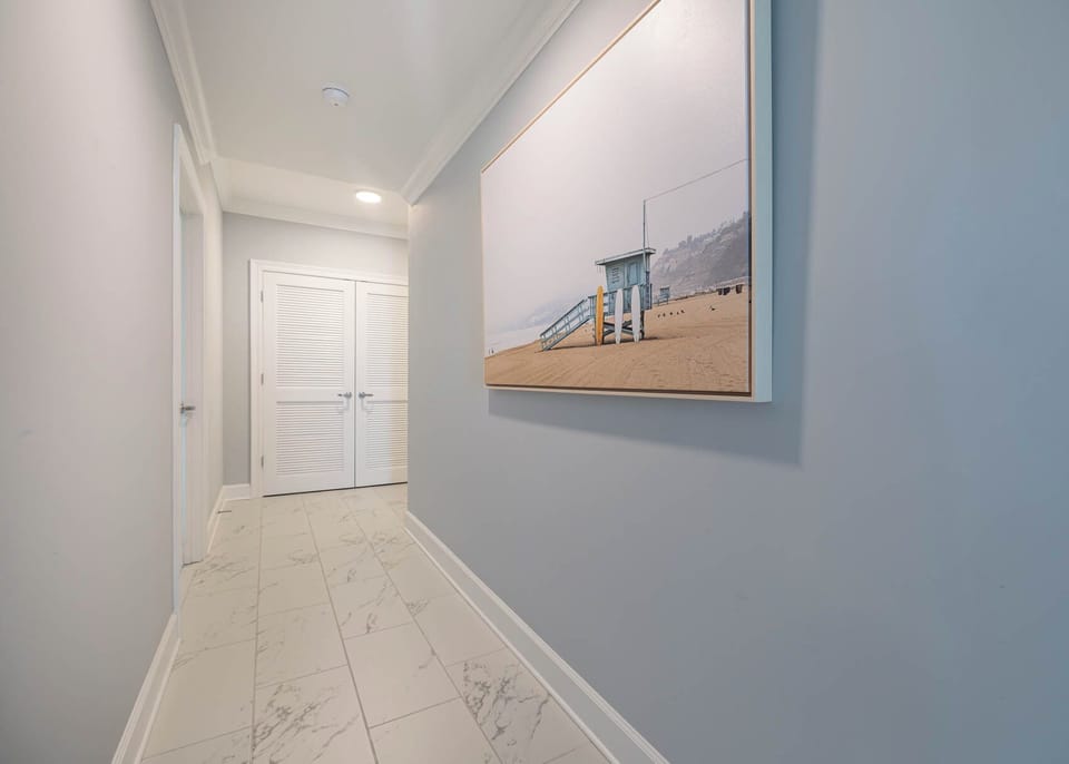 Step into this welcoming hallway adorned with beach artwork inviting you to your coastal getaway